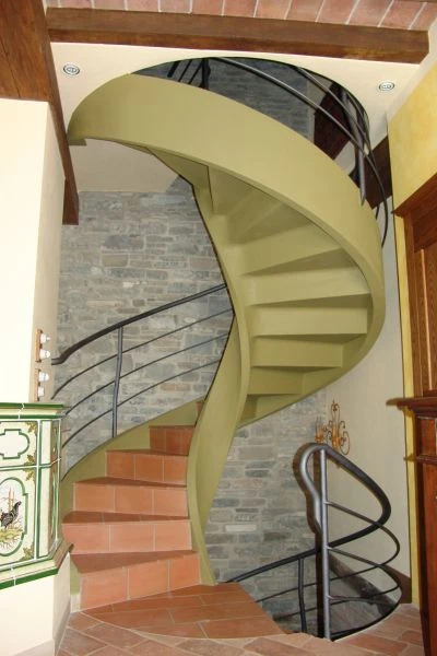 Scala elicoidale a Piacenza con gradini in cotto e struttura di cemento intonacata di colore verde