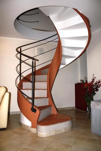 Scala per interni con struttura in calcestruzzo armato bianco e marrone moderna per una villa a Sarmato in provincia di Piacenza