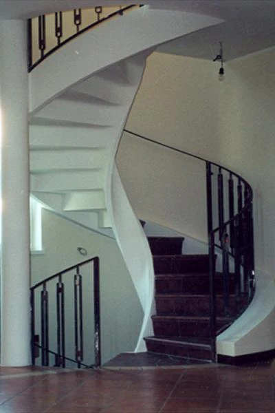 Scala per villa a Piacenza in calcestruzzo armato a forma di elica con gradini in marmo scuro e ringhiera metallica